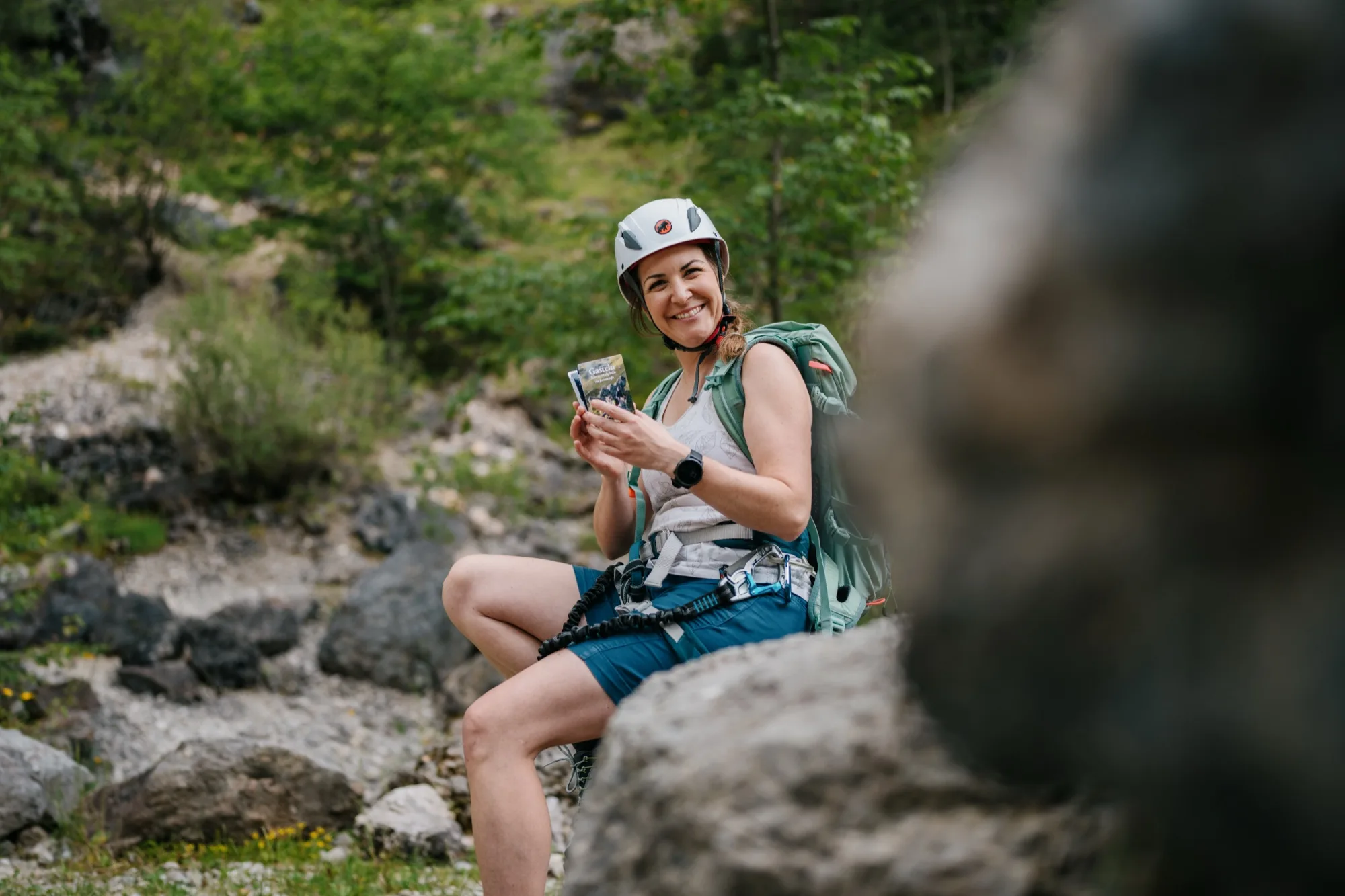 Escursionista con Pocketguide s-format in mano sulla via ferrata della Gasteinertal – compatta guida alle vie ferrate